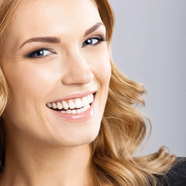 Joven mujer sonriente alegre, en gris —  Fotos de Stock