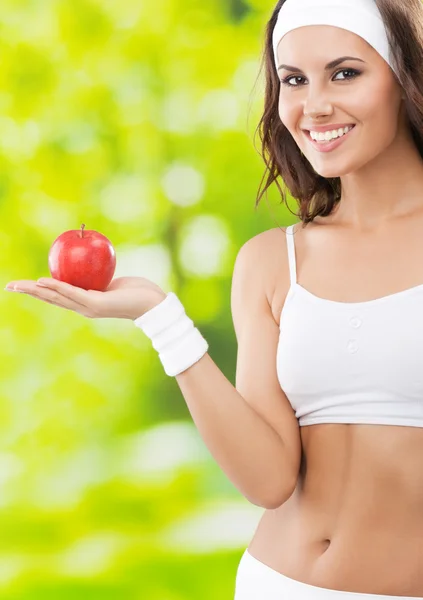 Femme en tenue de fitness avec pomme, à l'extérieur — Photo