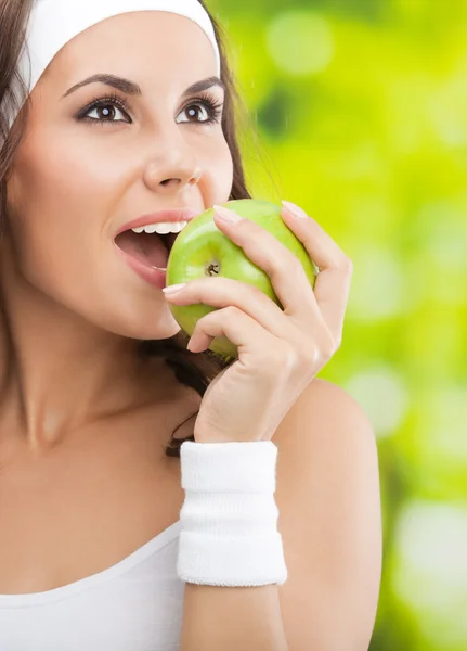 Frau in Fitnessbekleidung mit Apfel, im Freien — Stockfoto