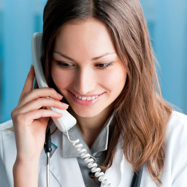 Young doctor on phone, at office — Stock Photo, Image