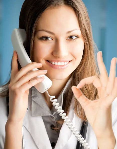 Jeune médecin au téléphone, au bureau — Photo