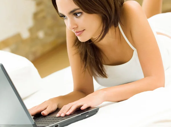 不同寻常微笑妇女工作用的笔记本电脑 — 图库照片