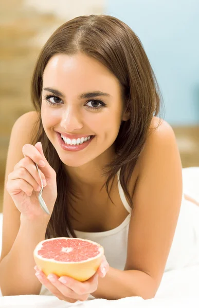 Porträt einer jungen Frau, die zu Hause Grapefruit isst — Stockfoto