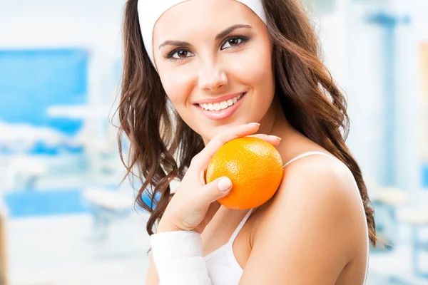 Mulher com laranja, no centro de fitness — Fotografia de Stock