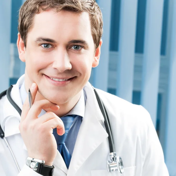 Happy smiling young doctor at office — Stock Photo, Image