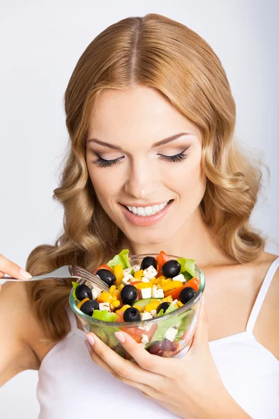 Vrouw met vegetarische salade, over grijs — Stockfoto