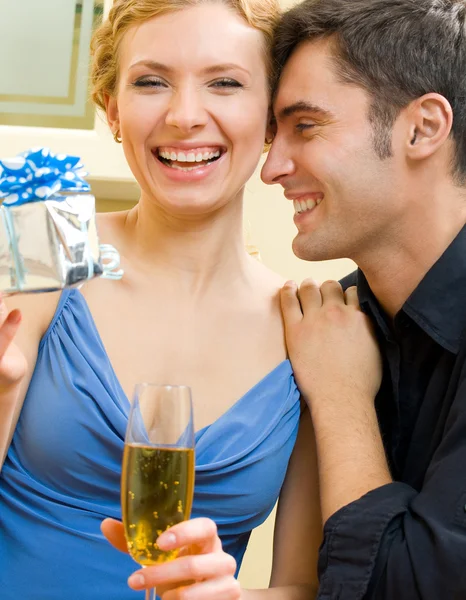 Cheerful amorous couple with gifts, indoors — Stock Photo, Image