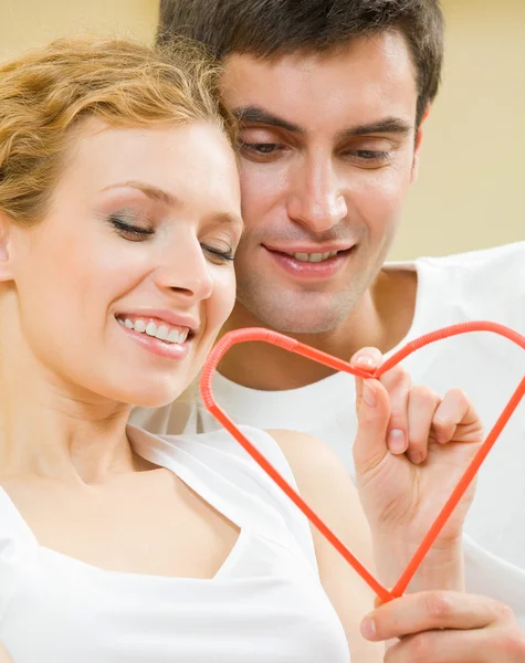 Young amorous couple with heart symbol — Stock Photo, Image