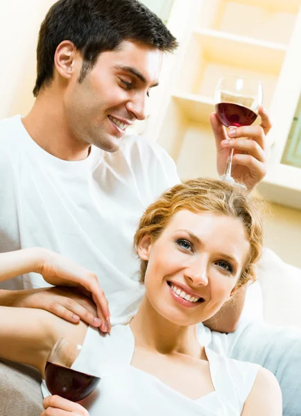 Casal alegre com copos de vinho tinto — Fotografia de Stock