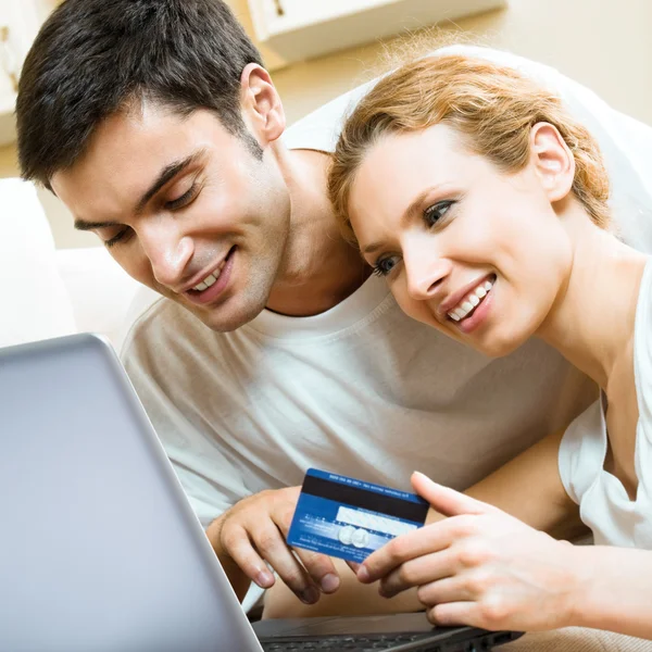 Cheerful couple paying by plastic card — Stock Photo, Image