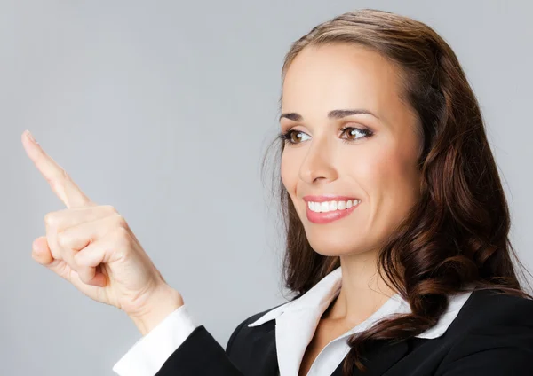 Mujer de negocios mostrando, sobre gris — Foto de Stock