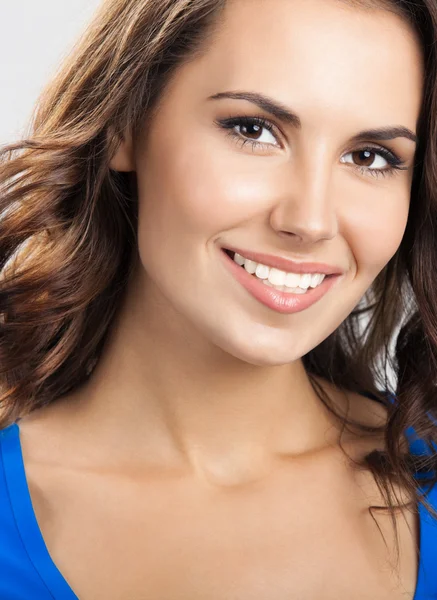 Щаслива усміхнена молода жінка, над сірою — стокове фото