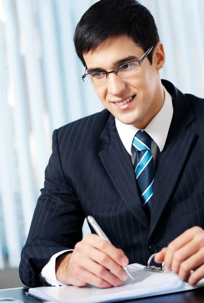 Portrait of writing smiling businessman working at office — Stock Photo, Image