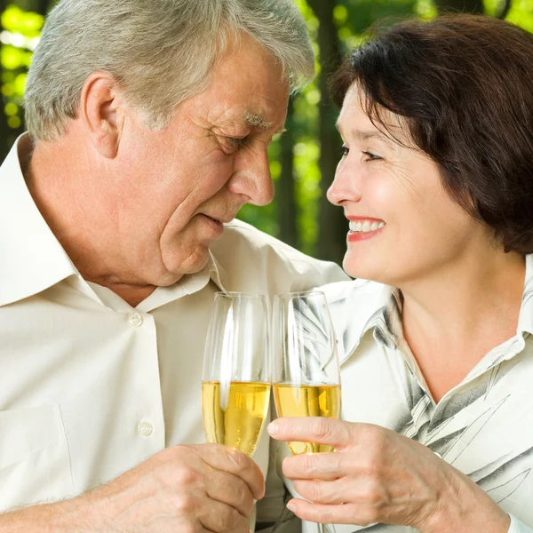 Äldre par firar med champagne, utomhus — Stockfoto