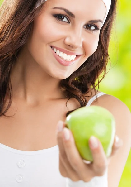 Mulher em desgaste fitness com maçã, ao ar livre — Fotografia de Stock