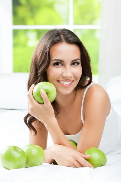 リンゴ、屋内の若い幸せな笑みを浮かべて女性 — ストック写真