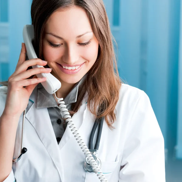 Jeune médecin au téléphone, au bureau — Photo