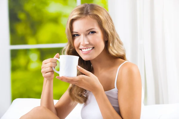 Fiatal nő iszik kávét vagy teát, otthon — Stock Fotó