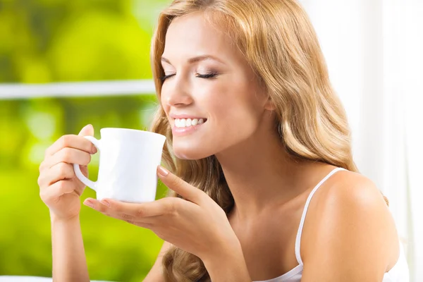 Jonge vrouw drinken koffie of thee, thuis — Stockfoto