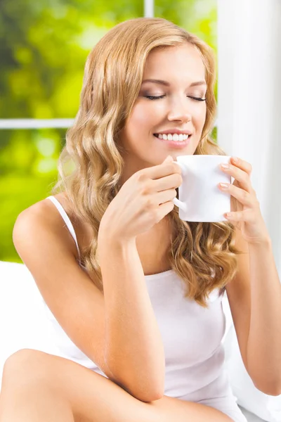 Jonge vrouw drinken koffie of thee, thuis — Stockfoto