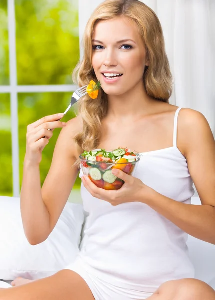 Donna che mangia insalata, in casa — Foto Stock