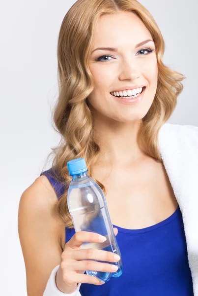 Mujer joven con agua y toalla — Foto de Stock