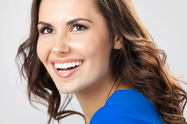 Happy smiling young woman, over grey — Stock Photo, Image