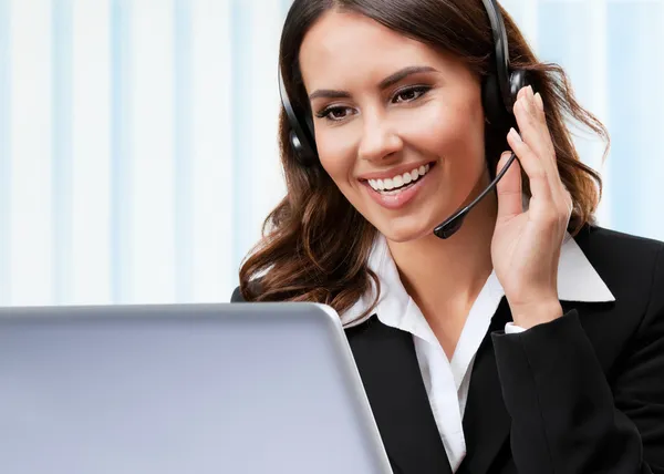 Soporte operador de teléfono en auriculares, trabajando con el ordenador portátil — Foto de Stock