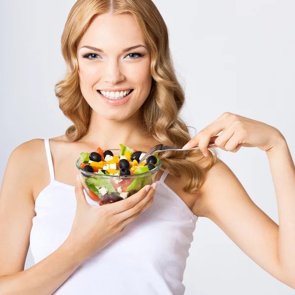 Vrouw met vegetarische salade, over grijs — Stockfoto