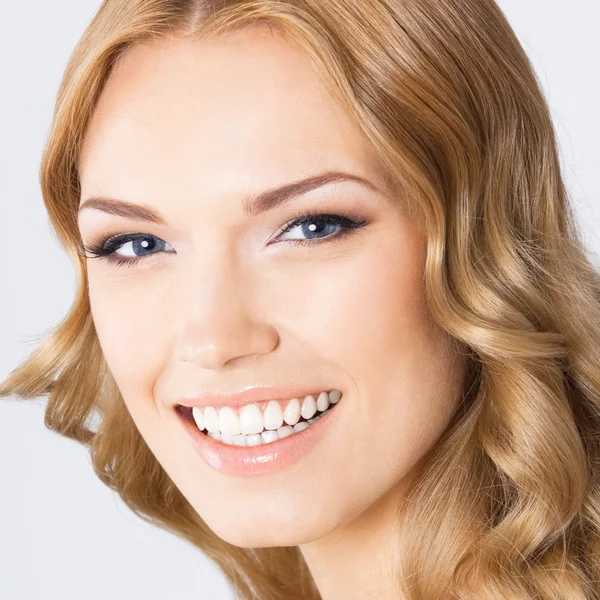 Joven mujer sonriente alegre, en gris —  Fotos de Stock