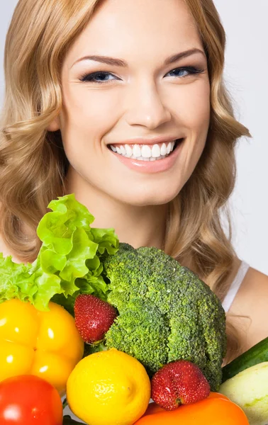 Mujer joven con comida vegetariana, sobre gris — Foto de Stock