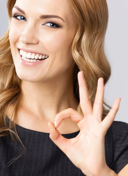 Деловая женщина с нормальным жестом, на сером — стоковое фото