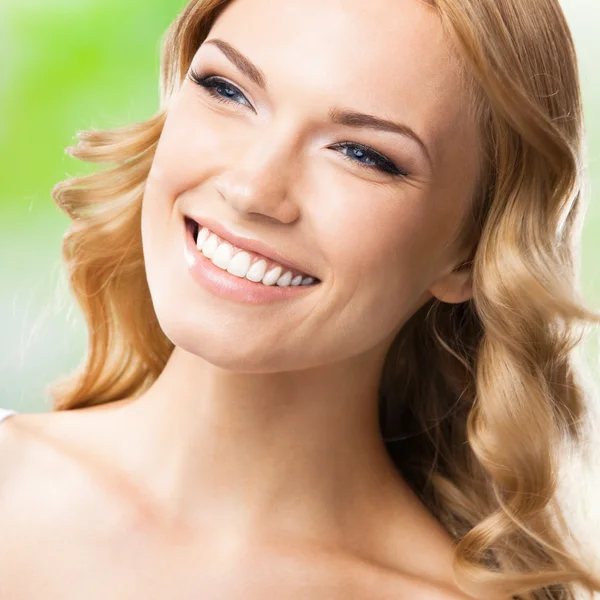 Gelukkig lachende vrouw met lang haar, buitenshuis — Stockfoto