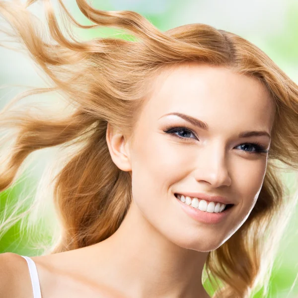 Glücklich lächelnde Frau mit langen Haaren, im Freien — Stockfoto