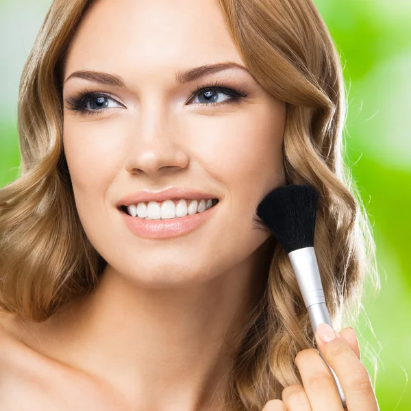 Lachende vrouw met make-up borstel, buiten — Stockfoto