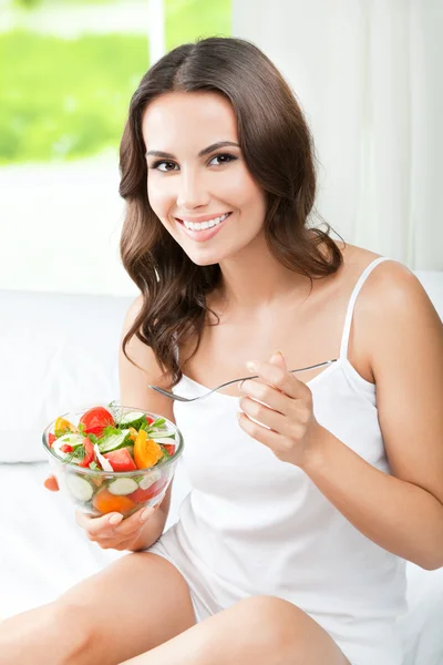 Donna che mangia insalata, in casa — Foto Stock