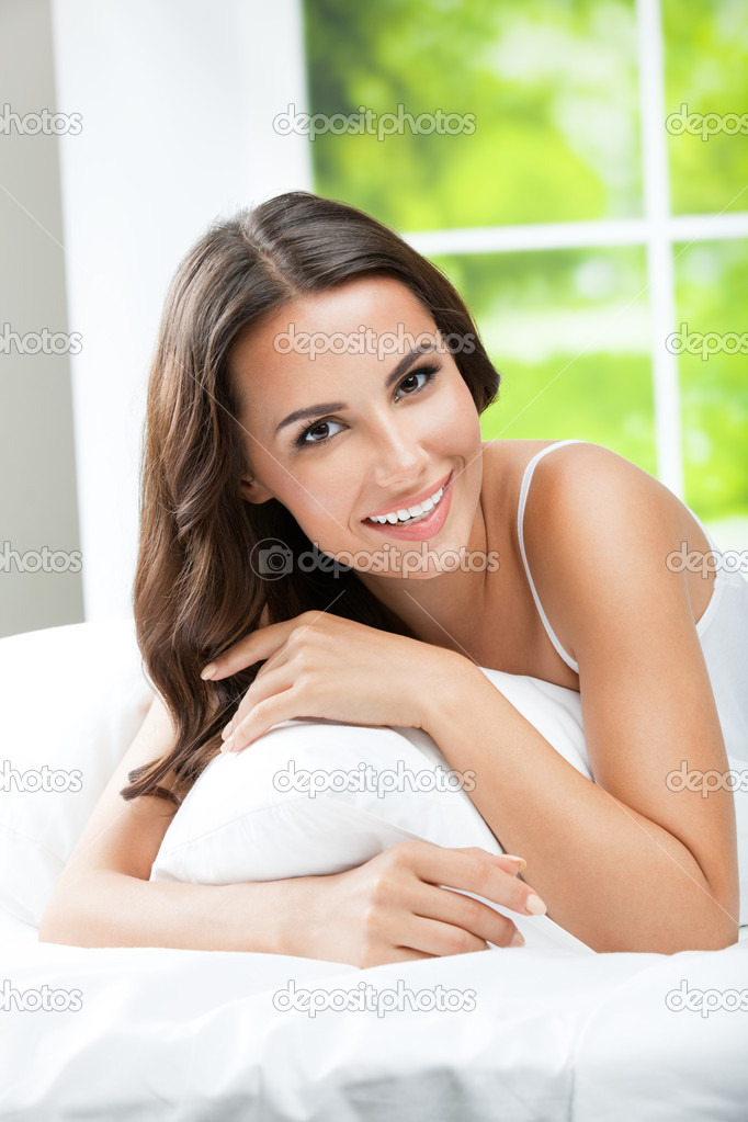 Young beautiful woman waking up, at bedroom