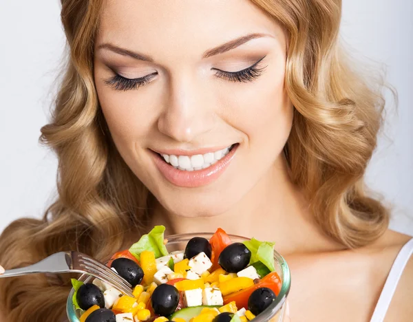 Vrouw met vegetarische salade, over grijs — Stockfoto