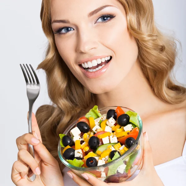 Mulher com salada vegetariana, sobre cinza — Fotografia de Stock