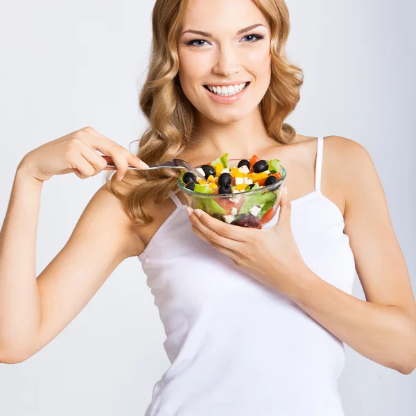 Mujer con ensalada vegetariana, sobre gris — Foto de Stock