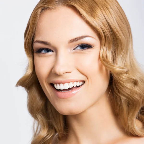 Jovem mulher sorridente alegre, em cinza — Fotografia de Stock