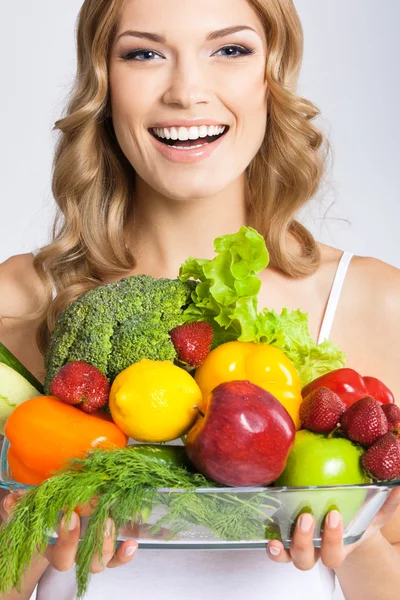 Młoda kobieta z wegetariańskie jedzenie, ponad szary — Zdjęcie stockowe