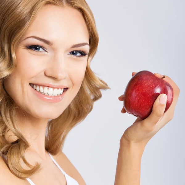 Woman with apple, on grey — Stock Photo, Image