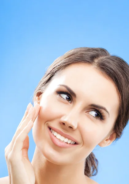 Frau, die Haut berührt oder Creme aufträgt, über blau — Stockfoto