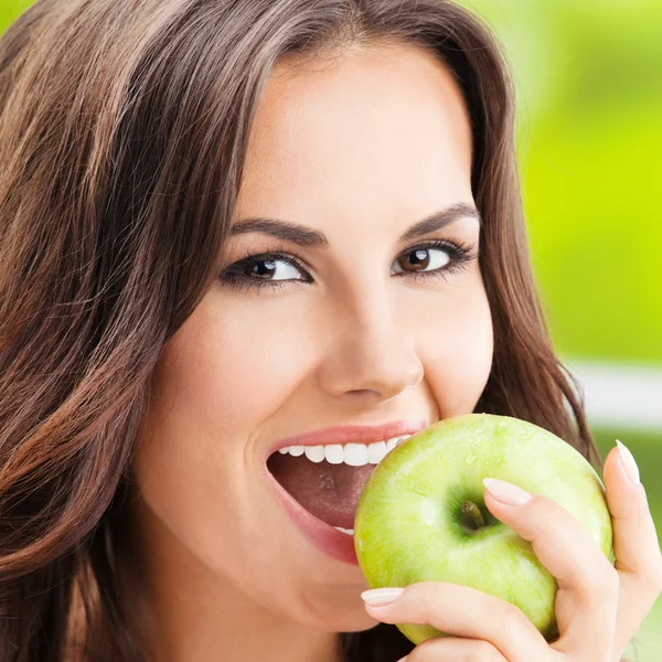 Jeune femme mangeant de la pomme, à l'extérieur — Photo