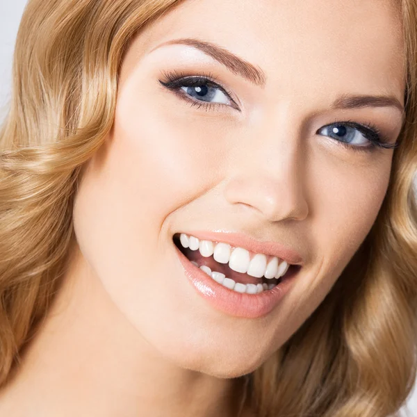 Jovem mulher sorridente alegre, em cinza — Fotografia de Stock