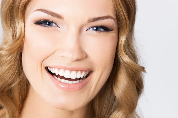 Joven mujer sonriente alegre, en gris —  Fotos de Stock