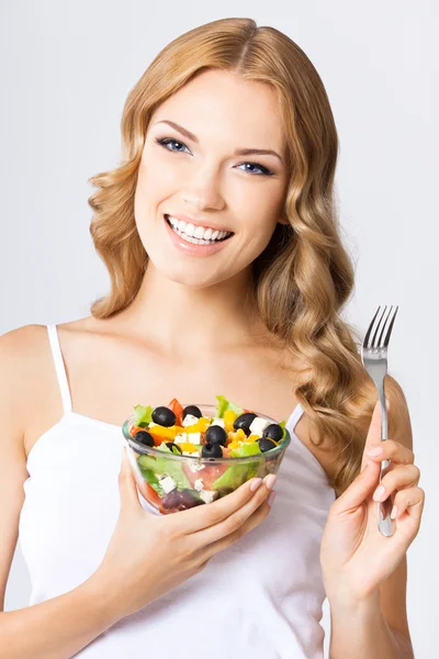 Vrouw met vegetarische salade, over grijs — Stockfoto
