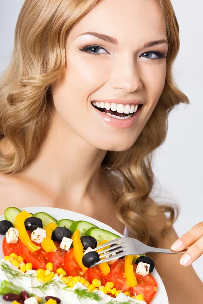 Vrouw met vegetarische salade, over grijs — Stockfoto