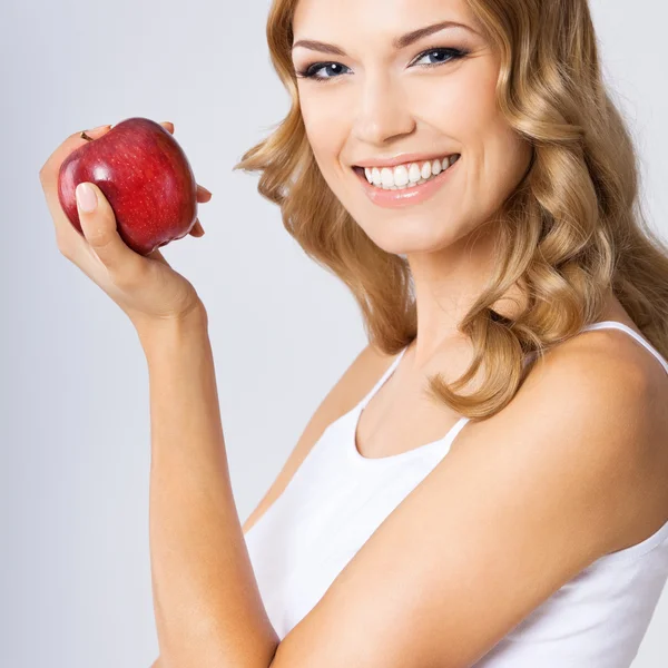 Femme avec pomme, sur gris — Photo